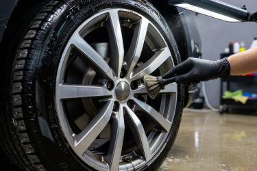 Real alloy wheel and tyre being cleaned during professional wheel detailing